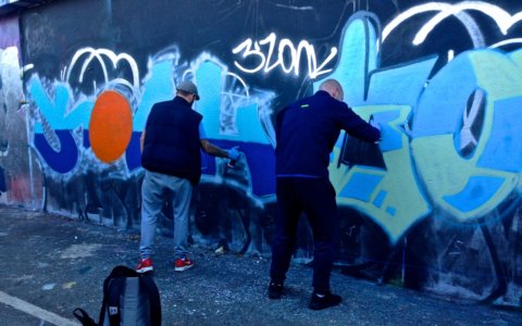 Graffiti artists creating a new piece at Allen Park in London, UK