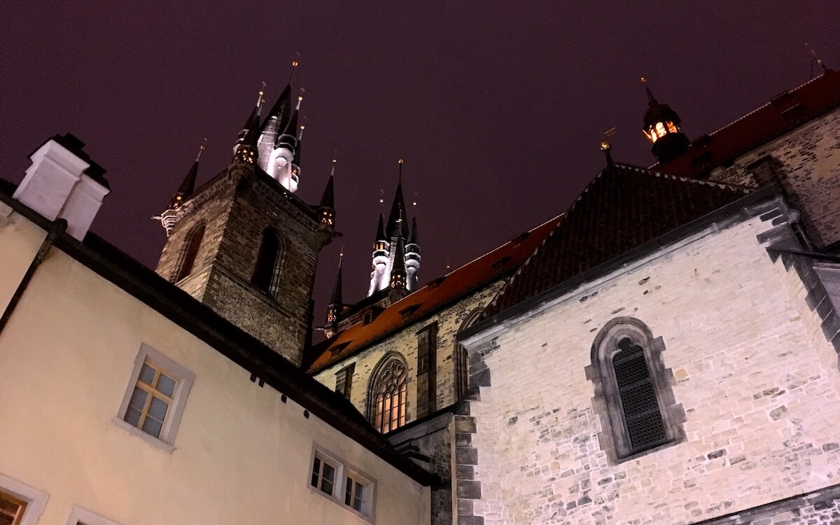 Nighttime view of Tyn Church in Prague with sinister looking red sky